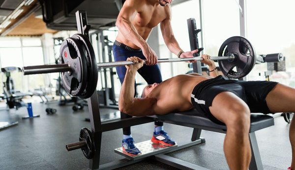 Zwei Männer machen Bankdrücken und zählen wie viele Sätze