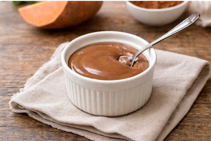 eine Schüssel Süßkartoffel-Schokoladen Proteinpudding mit einem Löffel darin