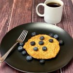 Süßkartoffel-Protein-Pfannkuchen auf einem Teller mit Blaubeeren