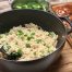 Ein Kochtopf gefüllt mit Reis mit Sesam, daneben etwas Hühnchen und Brokkoli