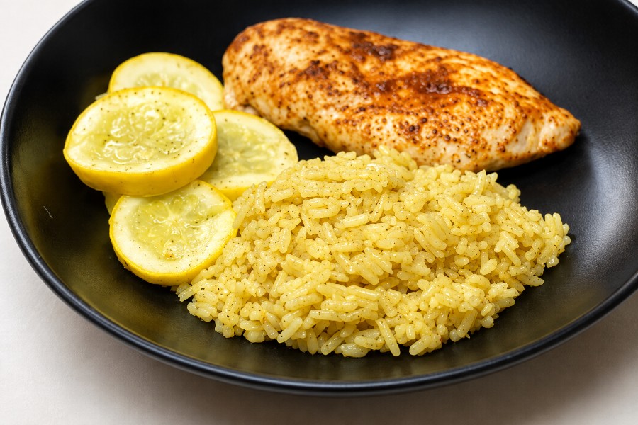 Ein Teller mit Kokos-Curry-Reis, Zucchini, und Hähnchenbrust