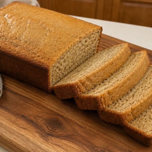 Bananenbrot auf einem Holzbrett mit vier Scheiben