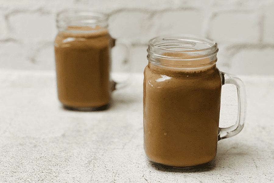 Zwei Glasbecher mit Schoko-Erdnussbutter-Protein Smoothie