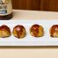 Vier Putenhackbällchen aus dem Ofen mit BBQ-Sauce auf einer weißen Platte.